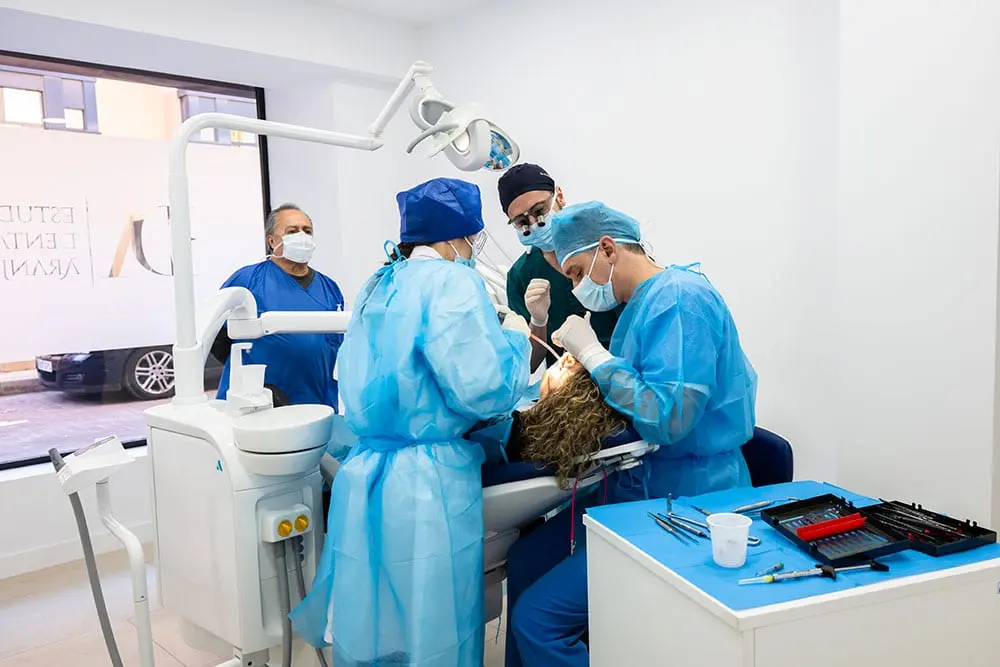 A surgical team of four around the chair during a procedure
